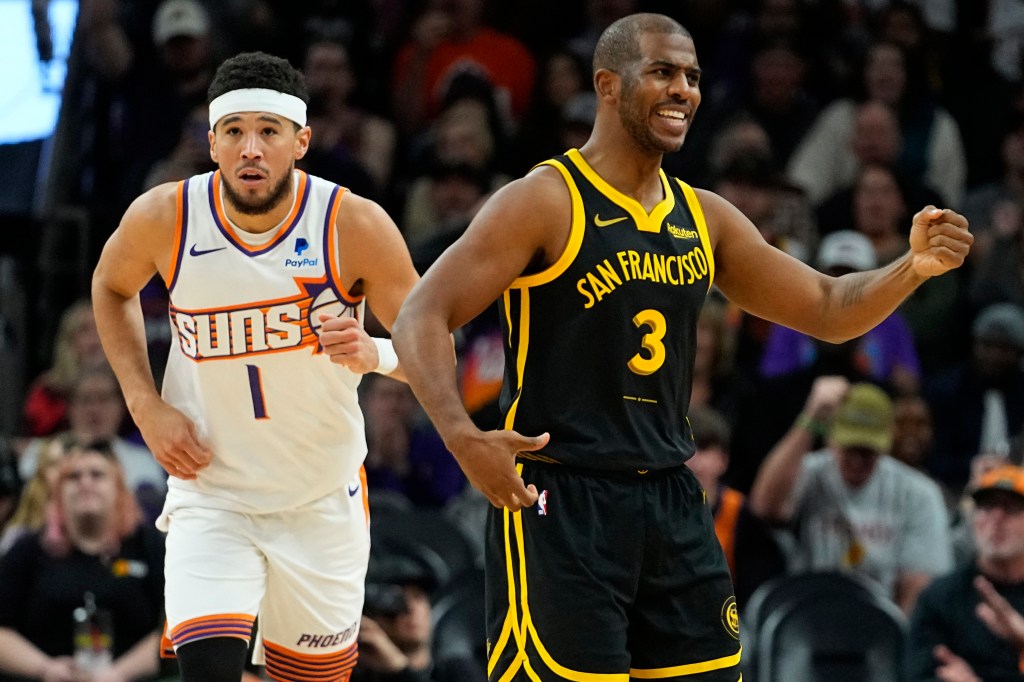 Golden State Warriors guard Chris Paul (3) looks for a call as Phoenix Suns guard Devin Booker runs up court after a basket during the first half of an NBA basketball game