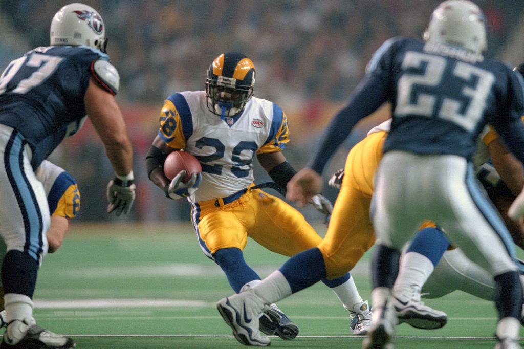 Marshall Faulk of St. Louis Rams carries the ball against the Tennessee Titans during Super Bowl XXXIV at the Georgia Dome on January 30, 2000 in Atlanta, Georgia. The Ram won the game 23-16. 