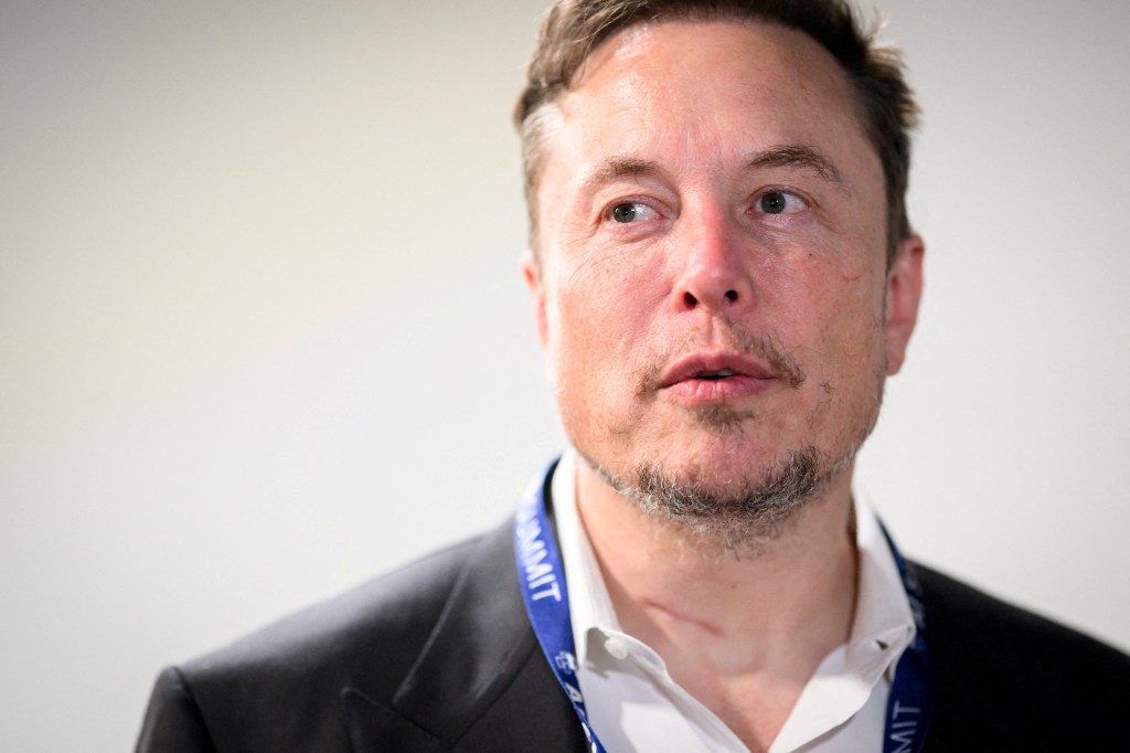 Musk standing at a conference and staring into space