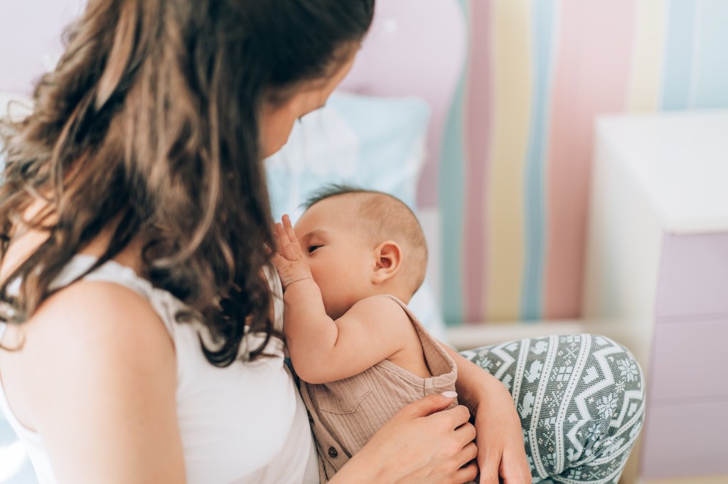 Young mother is breastfeeding her baby.