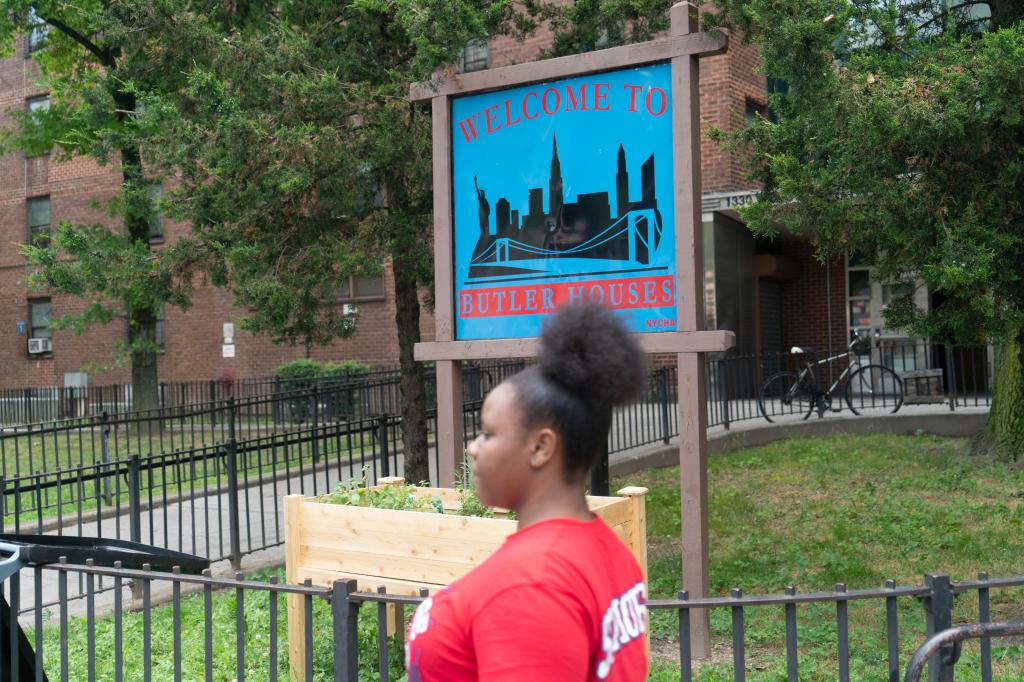 A woman passes by the front of Butler Houses, a housing project in The Bronx.