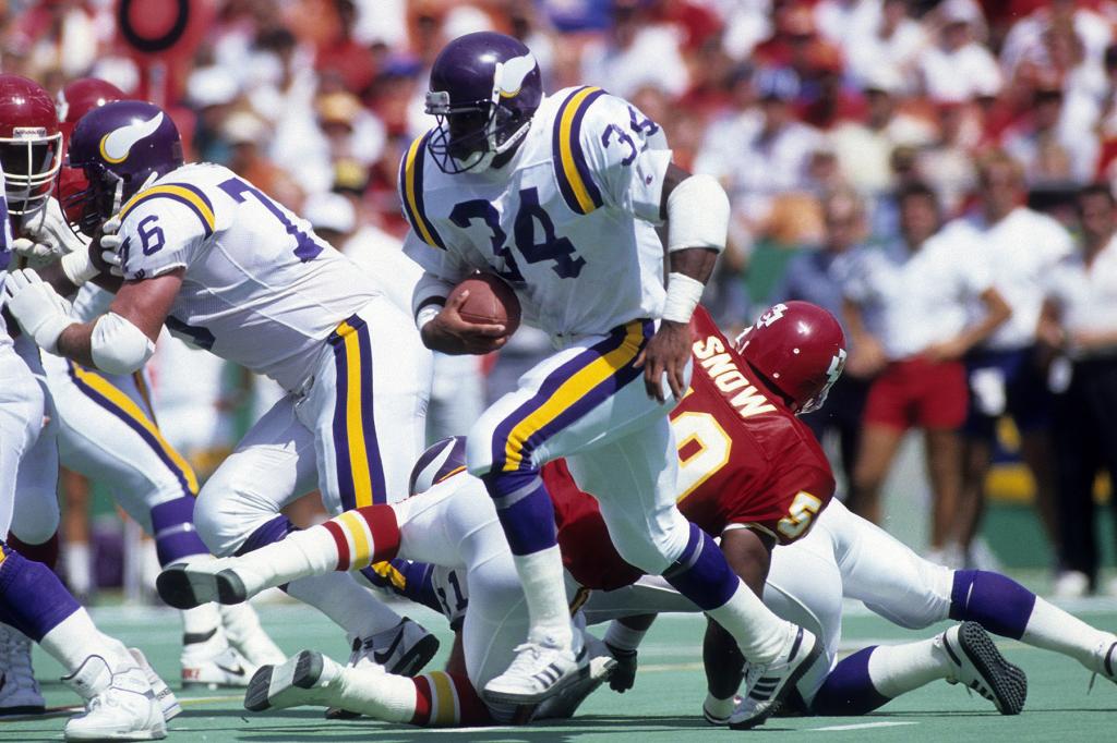 Running back Herschel Walker #34 of the Minnesota Vikings carries the ball against the Kansas City Chiefs during an NFL football game circa early 1990's at Arrowhead Stadium in Kansas City, Missouri. Walker played for the Viking from 1989-91. 