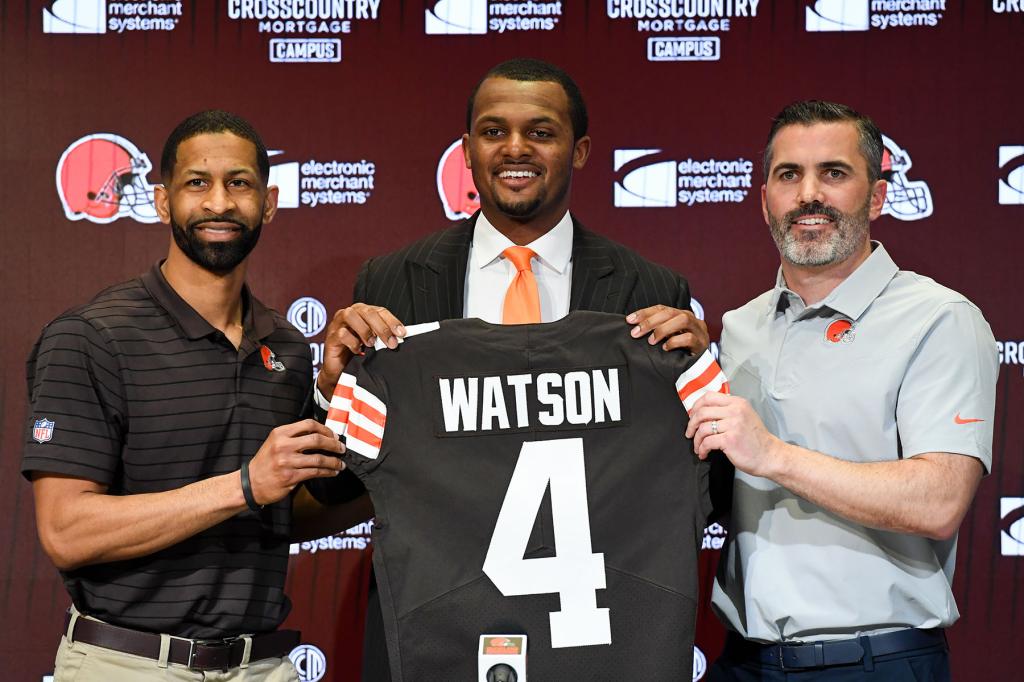 Quarterback Deshaun Watson #4 of the Cleveland Browns is introduced by general manager Andrew Berry (L) and head coach Kevin Stefanski during a press conference at CrossCountry Mortgage Campus on March 25, 2022 in Berea, Ohio