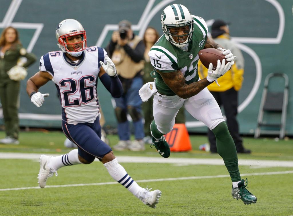 New York Jets wide receiver Brandon Marshall (15) catches a pass for a touchdown in front of New England Patriots' Logan Ryan (26) during the second half of an NFL football game, Sunday, Dec. 27, 2015, in East Rutherford, N.J.