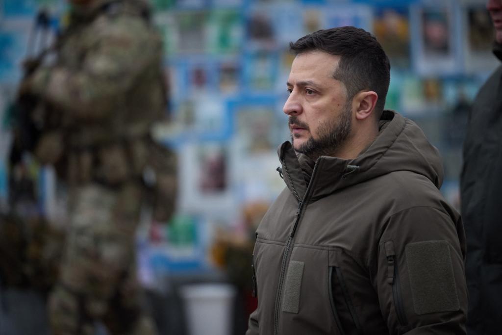 This handout photograph taken and released by the Ukrainian Presidential Press Service on December 6, 2023, shows the Ukrainian President Volodymyr Zelensky looking on as he pays his respects in front of The Wall of Remembrance of the Fallen for Ukraine, in Kyiv.