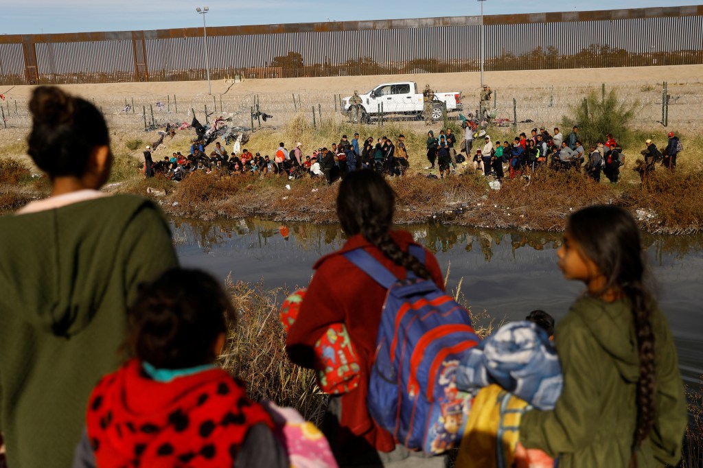 Migrants seeking asylum in the United States gather on the banks of the Rio Bravo river, as the Texas National Guard blocks the crossing at the border between the United States and Mexico.