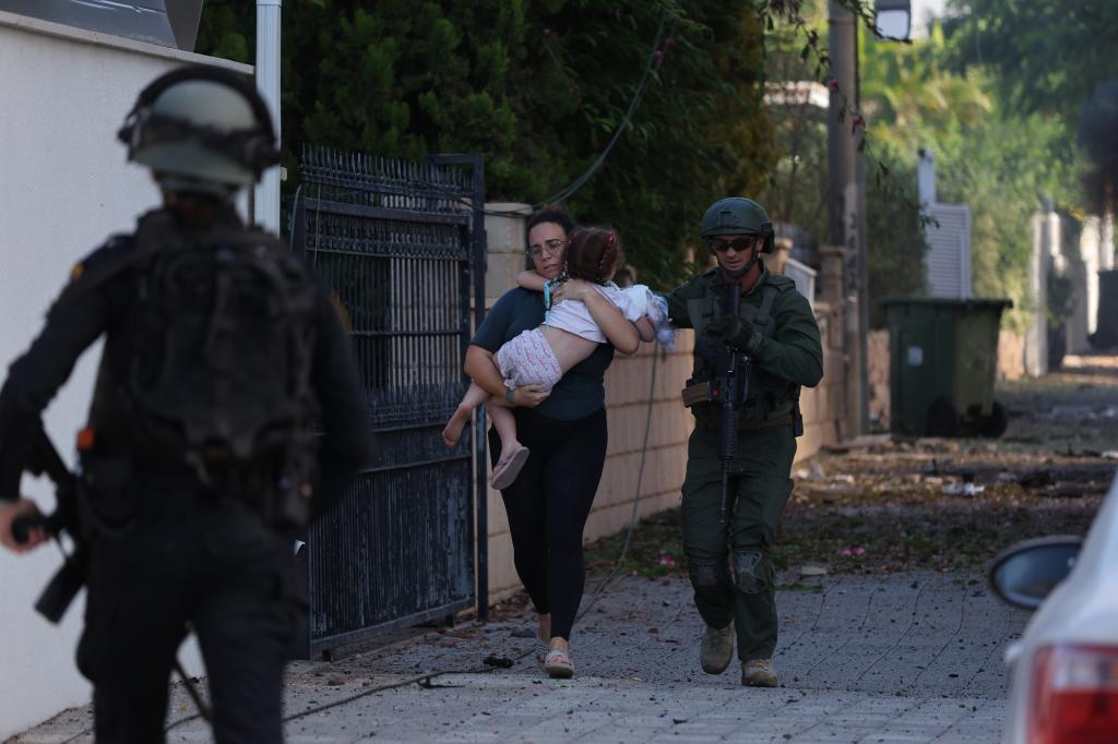 Members of Israeli police help people evacuate in Ashkelon, southern Israel, Oct. 7, 2023. 