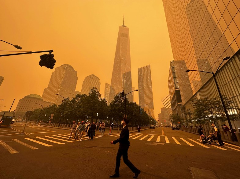 Pedestrians pass the World Trade Center, as a smokey haze from Canada wildfires engulfs the city Wednesday, June 7, 2023.