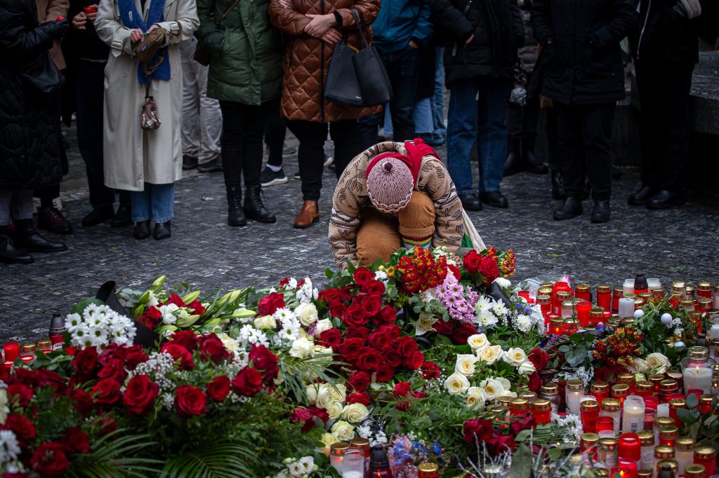 People lay flowers outside the Charles University building following a mass shooting