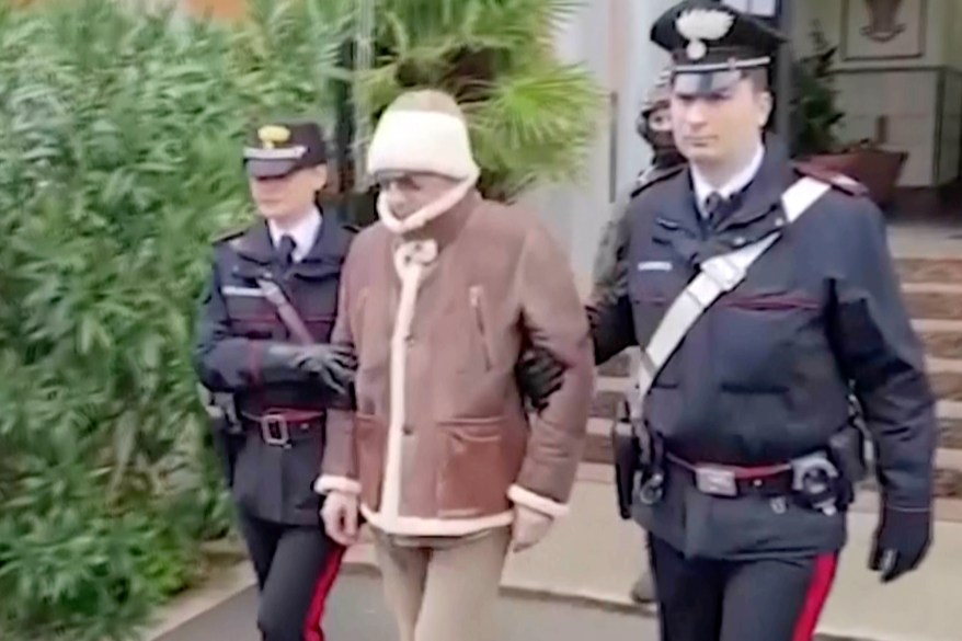 Italy's most wanted fugitive Matteo Messina Denaro, a top Mafia boss, being escorted from a Carabinieri police station shortly after his arrest, in Palermo, southern Italy, Jan. 16, 2023.