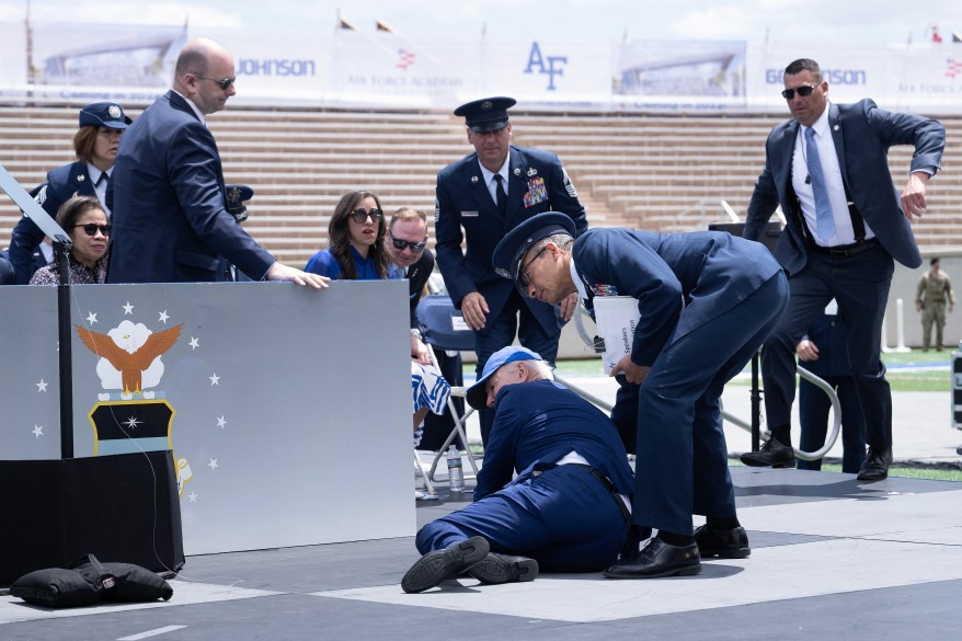 US President Joe Biden is helped up after falling during the graduation ceremony at the United States Air Force Academy, just north of Colorado Springs in El Paso County, Colorado, on June 1, 2023.