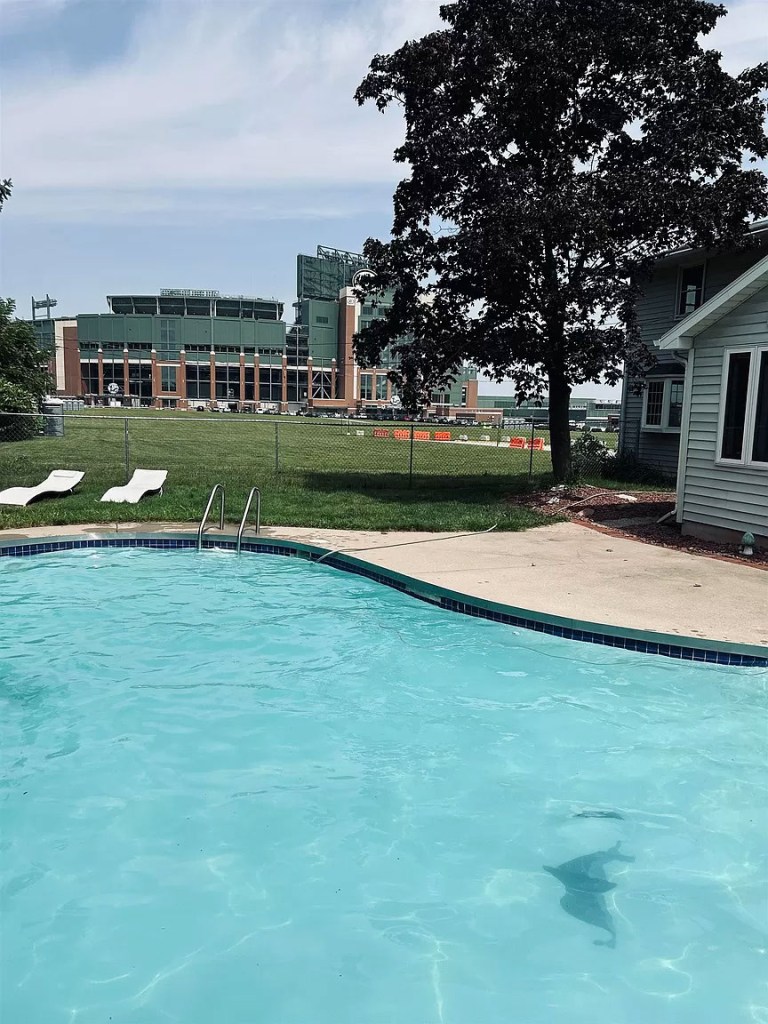 The backyard of the home features an expansive pool and Lambeau Field. 