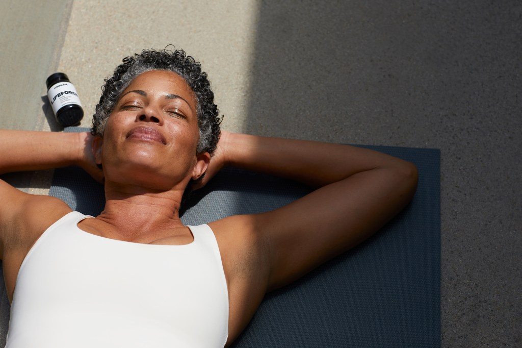 Woman relaxing with Lifeforce bottle