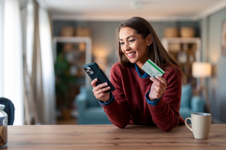 A woman researches credit card options on her phone.