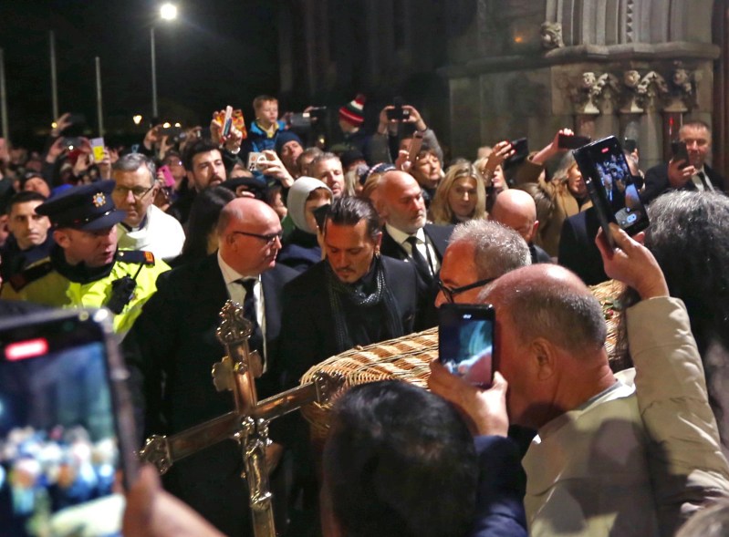 Johnny Depp helps carry the wicker casket of Pogues singer Shane MacGowan out of Saint Mary's of the Rosary Church to a waiting hearse following the funeral mass in Nenagh, County Tipperary, Ireland, on Dec. 8 2023.