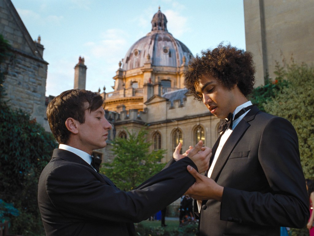 Barry Keoghan and Archie Madekwe in "Saltburn" standing facing each other. 