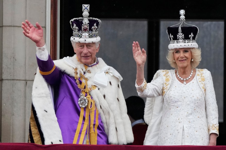 King Charles III and Queen Camilla wave to the crowds from the balcony of Buckingham Palace after the coronation ceremony in London, Saturday, May 6, 2023.