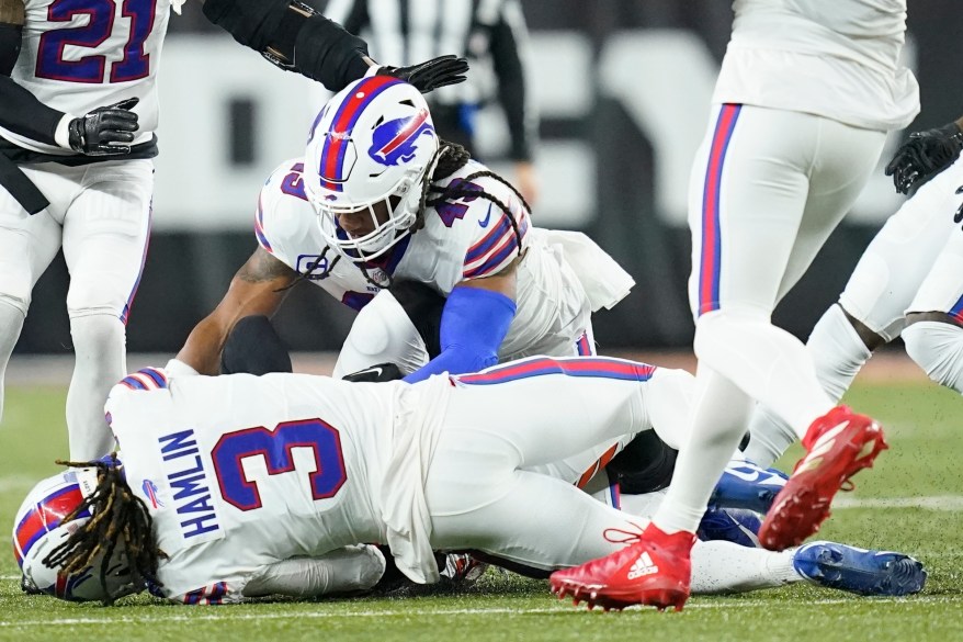 Buffalo Bills safety Damar Hamlin falls to the turf as Buffalo Bills linebacker Tremaine Edmunds helps. During a Monday Night Football game against the Cincinnati Bengals on January 2, 2023, Hamlin suffered a cardiac arrest after making a tackle.