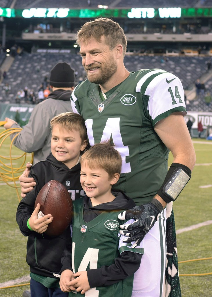 New York Jets quarterback Ryan Fitzpatrick poses with his sons, Brady, left, and Tate, right, after the Jets defeated the Miami Dolphins on Nov. 29, 2015, in East Rutherford, N.J.