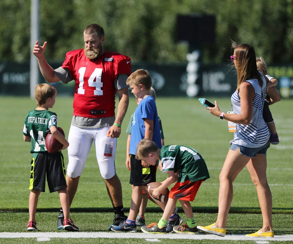 New York Jets quarterback Ryan Fitzpatrick, second from left, relaxes with his family after practice at the NFL football teams training camp in Florham Park, N.J., Wednesday, Aug. 3, 2016. (AP Photo/Seth Wenig)