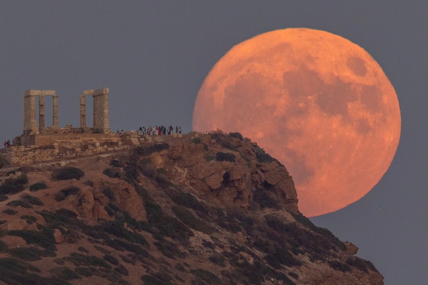 A full moon known as the "Blue Moon" rises behind the Temple of Poseidon, in Cape Sounion, near Athens, Greece, August 30, 2023.