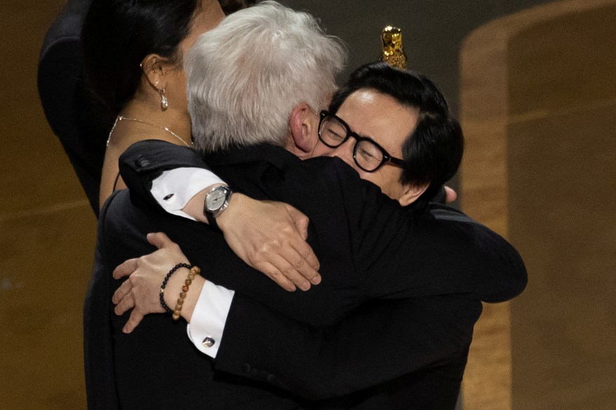 Ke Huy Quan hugs Harrison Ford after receiving the Oscar for Best Picture for "Everything Everywhere All at Once" during the Oscars show at the 95th Academy Awards in Hollywood, Los Angeles, California, U.S., March 12, 2023.