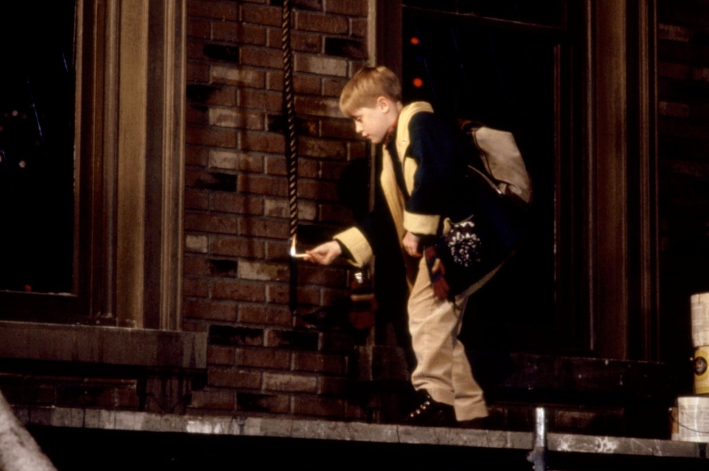 Macaulay Culkin lights the end of a rope on fire in a still image taken from "Home Alone 2: Lost in New York"