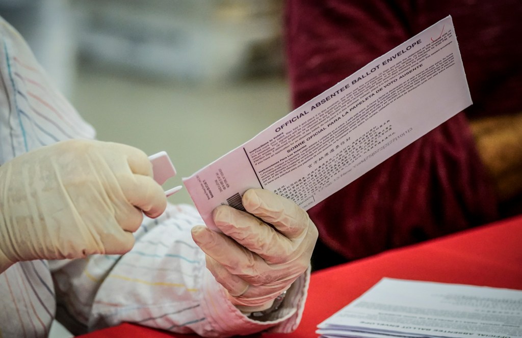 New York City Board of Election staff member removes an absentee ballot from the envelope as she helps count ballots in the primary election, Friday, July 2, 2021, in New York