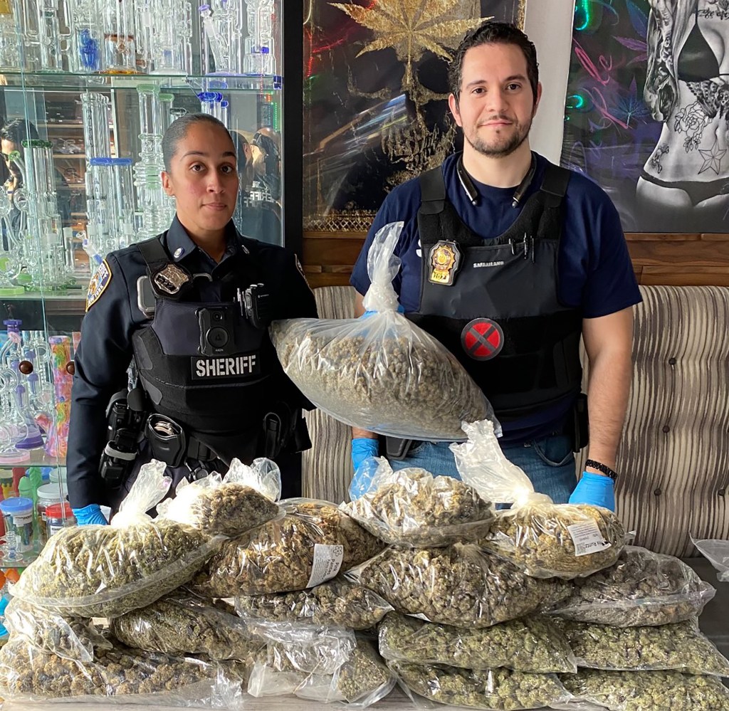 Officers with the New York City Sheriff’s Joint Compliance Task Force with marijuana confiscated from illegal stores.