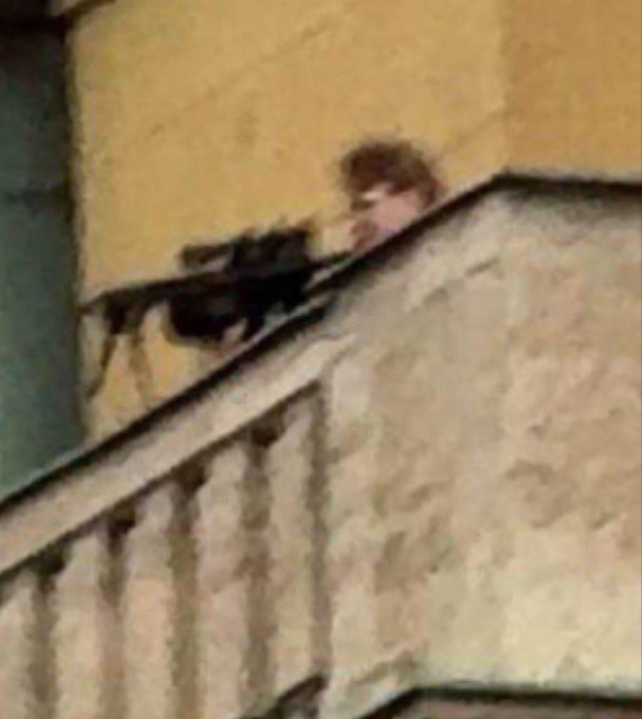 A screenshot shows what appears to be the gunman aiming his rifle on the balcony of Charles University in Prague Thursday