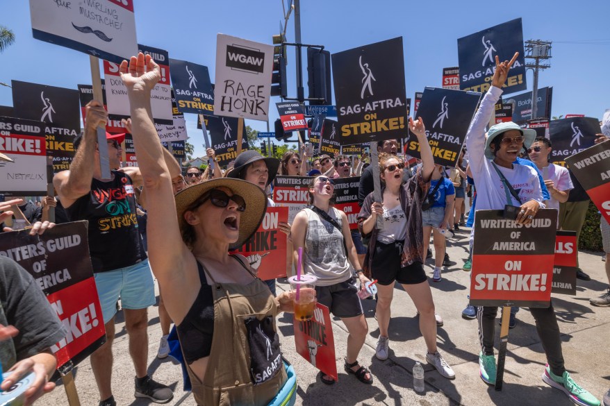 Members of the Hollywood actors SAG-AFTRA union walk a picket line with screenwriters outside of Paramount Studios on the first day of the actors' strike on July 14, 2023 in Los Angeles, California.