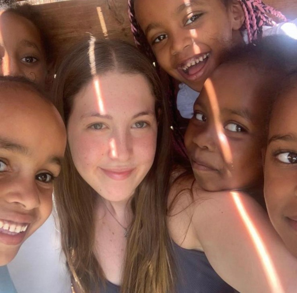 Naama Levy in a selfie surrounded by smiling young children.