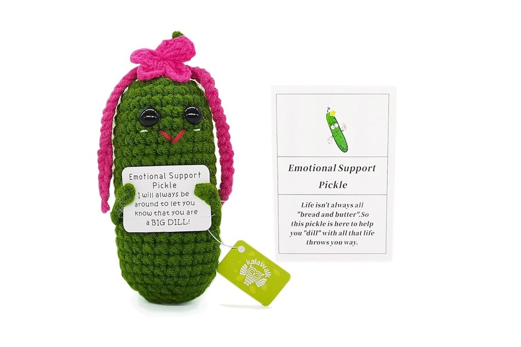 A stuffed toy resembling a pickle with a sign next to it