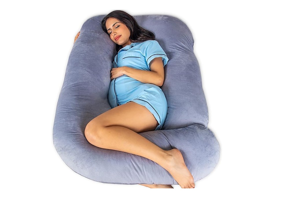 A woman sleeping on a pregnancy pillow