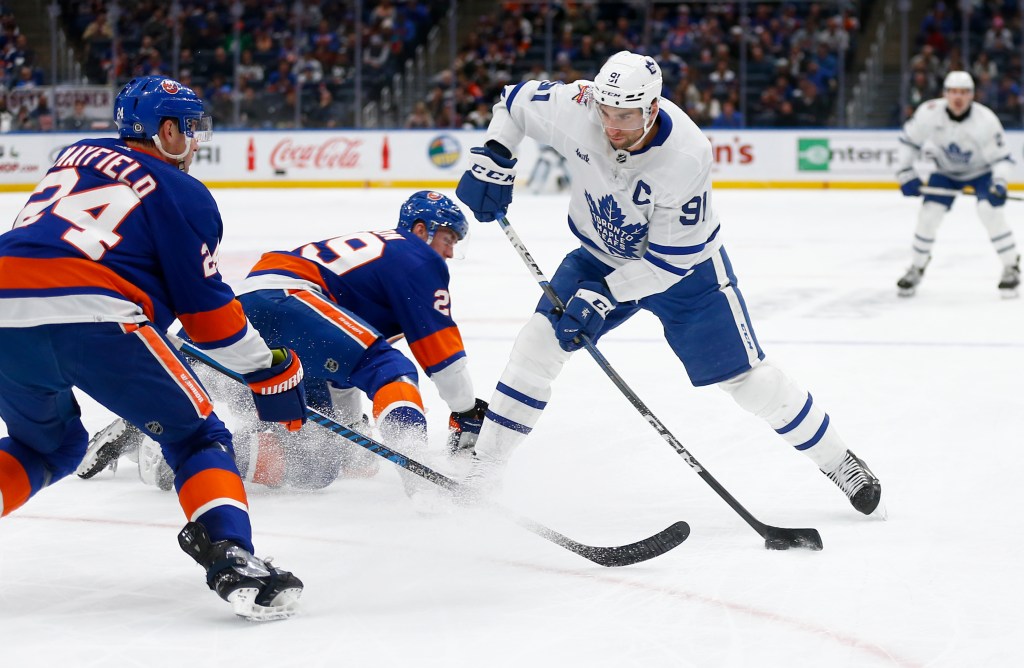 John Tavares prepares to shoot the puck past New York Islanders defenseman Scott Mayfield (24) and center Brock Nelson (29) during the third period.