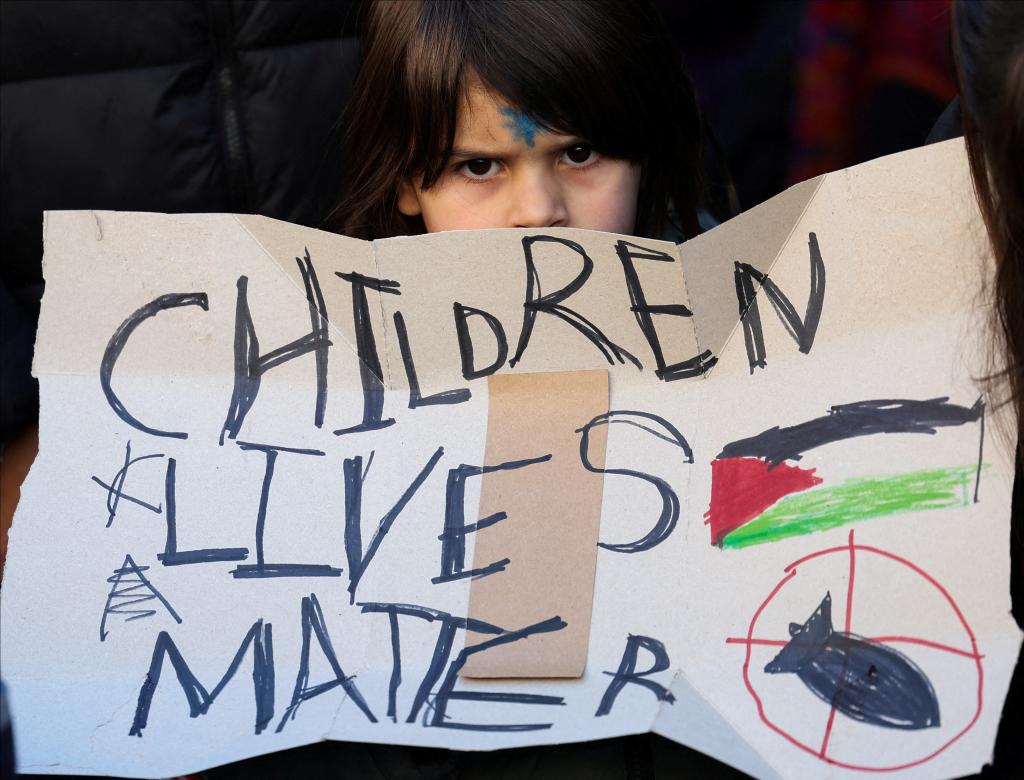 a child at a pro-hamas protest holds up a sign reading children lives matter