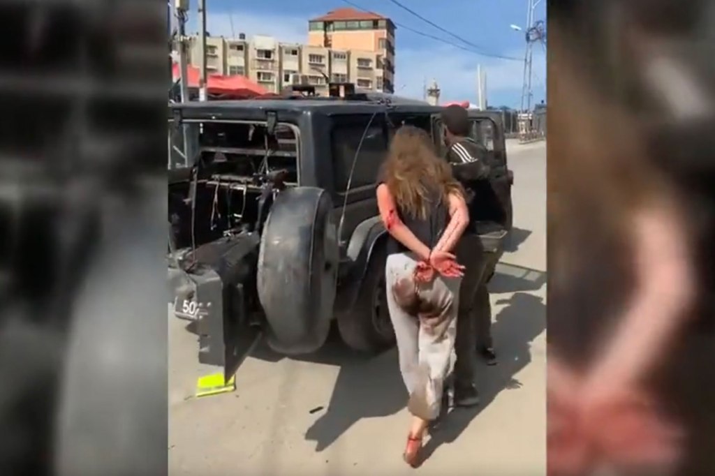 Israeli teen Naama Levy is bloodied and has her hands tied as she is led towards a Jeep