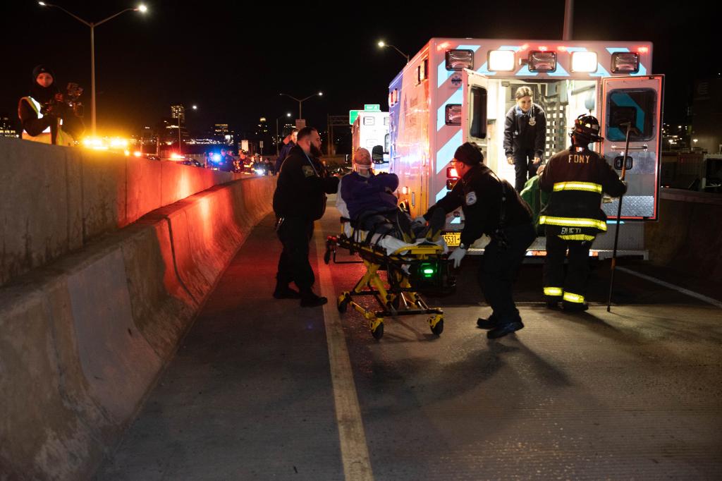 Ambulance workers load an injured man into an emergency vehicle.