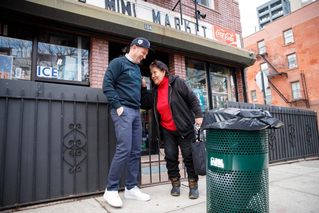 Sean Feeney and Milly's Mini Mart Paula Lopez speak in front of her store.