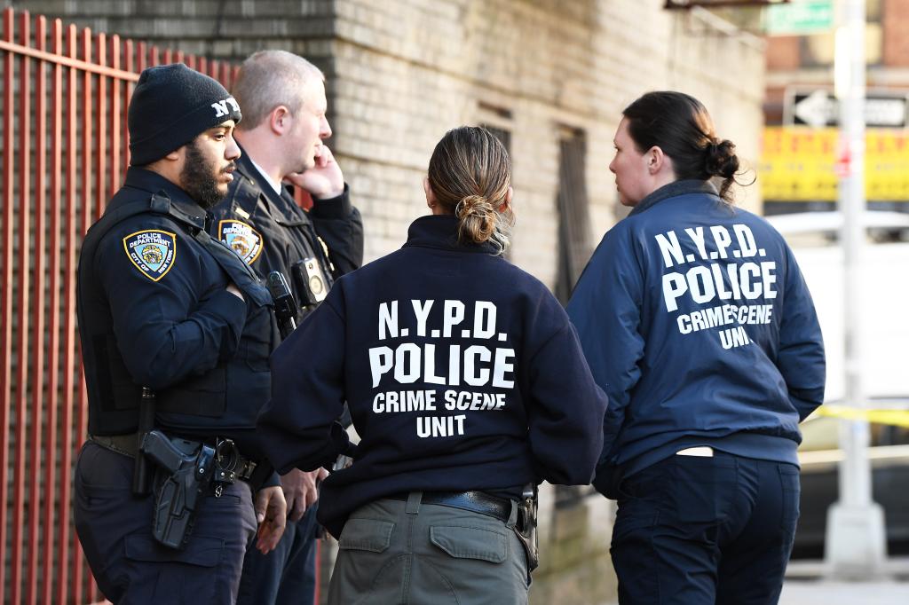 NYPD officers stand outside a crime scene in the Bronx. 