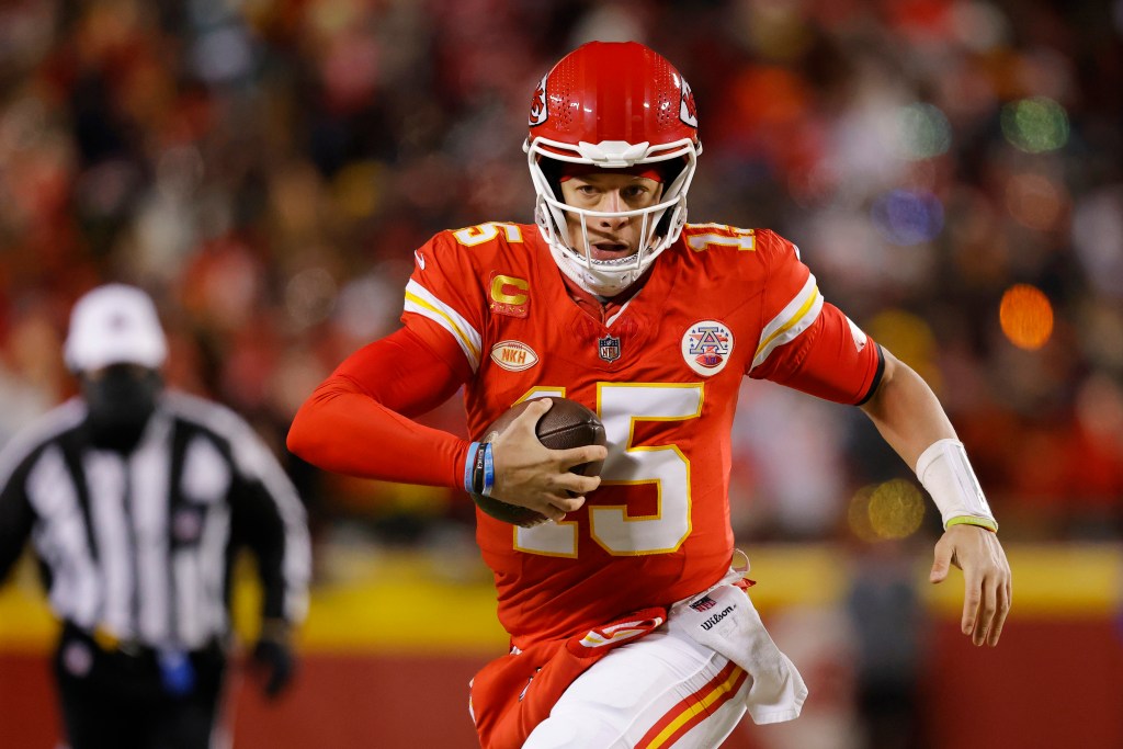 Chiefs quarterback Patrick Mahomes runs with the ball against the Dolphins on Jan. 13, 2024.