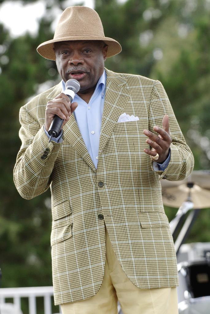 A photo of Willie Brown wearing a checkered sport coat, yellow pants and a tan fedora.