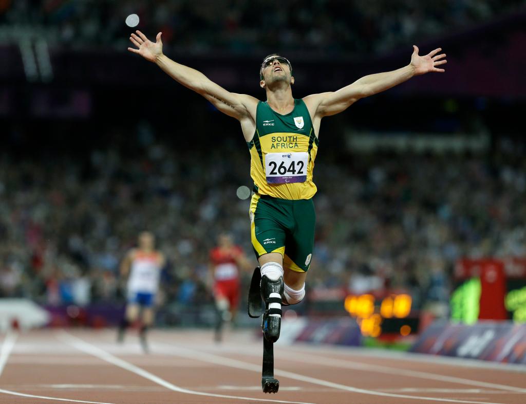 Oscar Pistorius raises arms in celebration on track