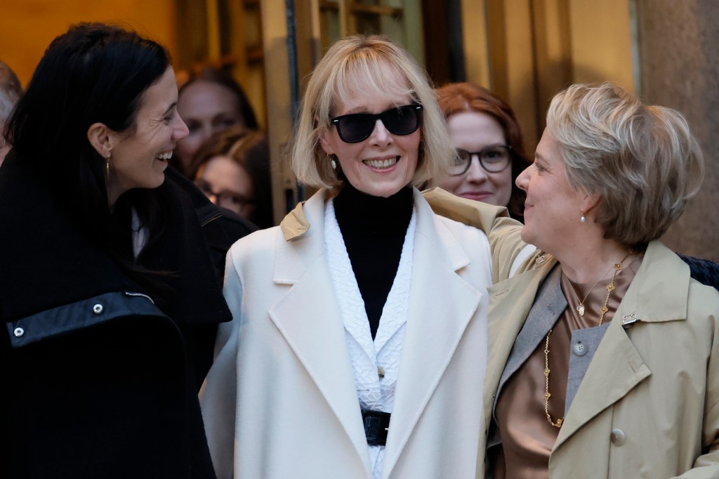 E. Jean Carroll leaves Manhattan Federal Court, holding a white purse, amid several people on a snowy street in New York City.