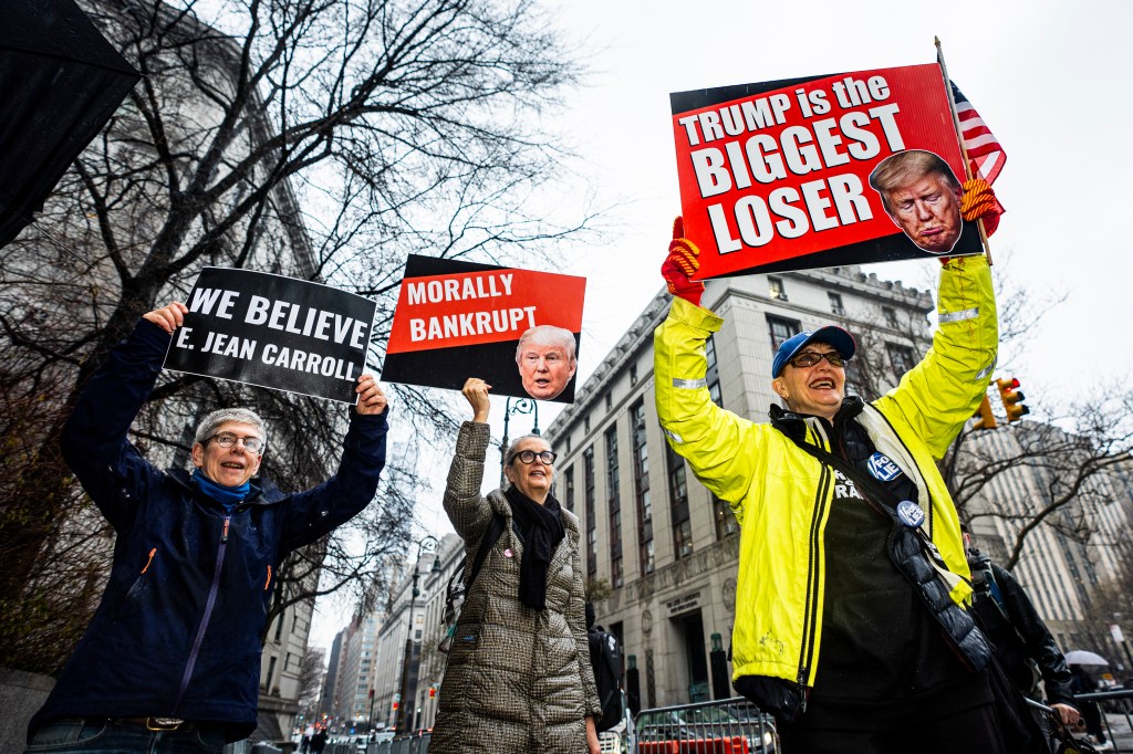 Protesters with signs gather outside Federal Court in New York where Donald Trump may appear in a lawsuit regarding E. Jean Carroll.