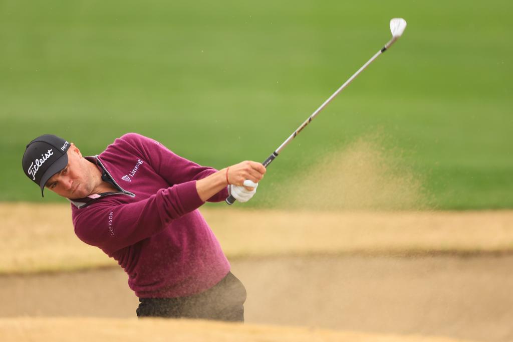 Justin Thomas, who is in third place, four shots off the lead, plays a shot from the bunker on the 18th holed of the third round of The American Express.