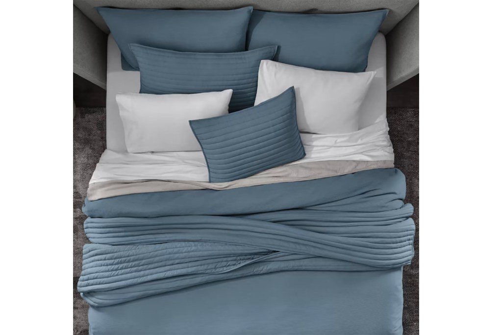 Blue and white pillows on a bed.