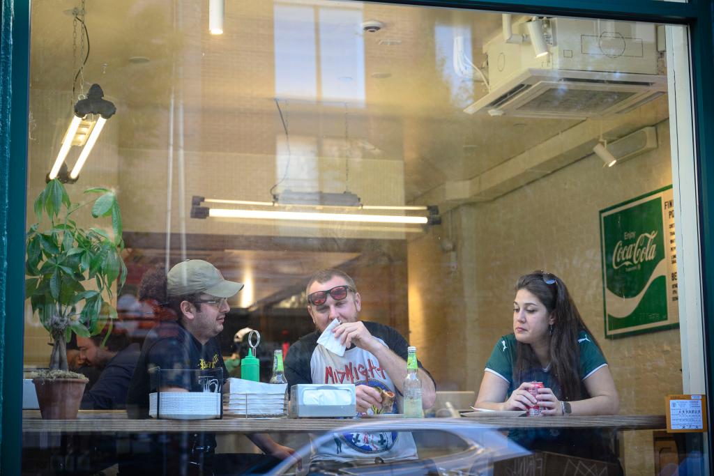 People eating in the window of Fini Pizza