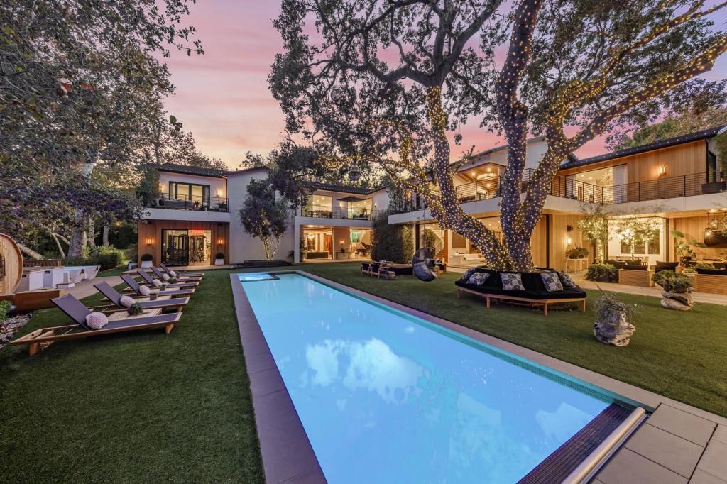 A pool and lounging area in the backyard.