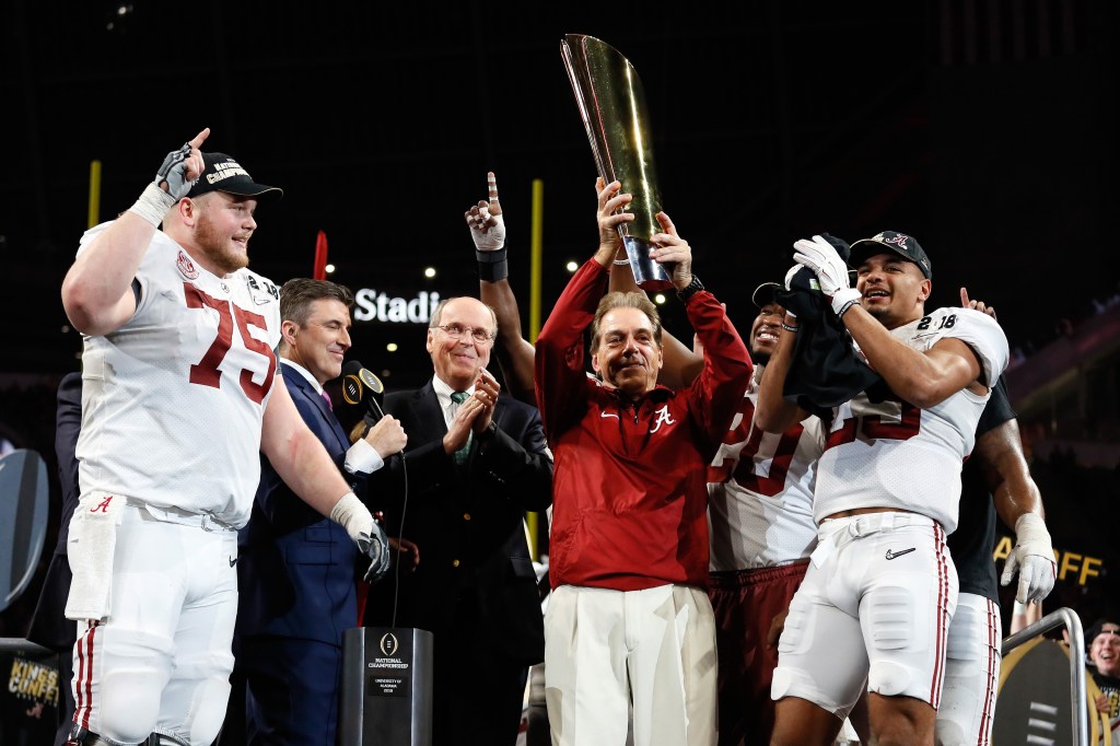 Head coach Nick Saban of the Alabama Crimson Tide holds the trophy while celebrating with his team